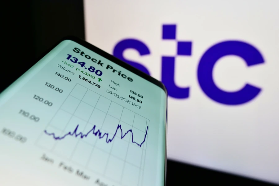 Smartphone with website of Arabian carrier Saudi Telecom Company (STC) on screen in front of company logo. Shutterstock.