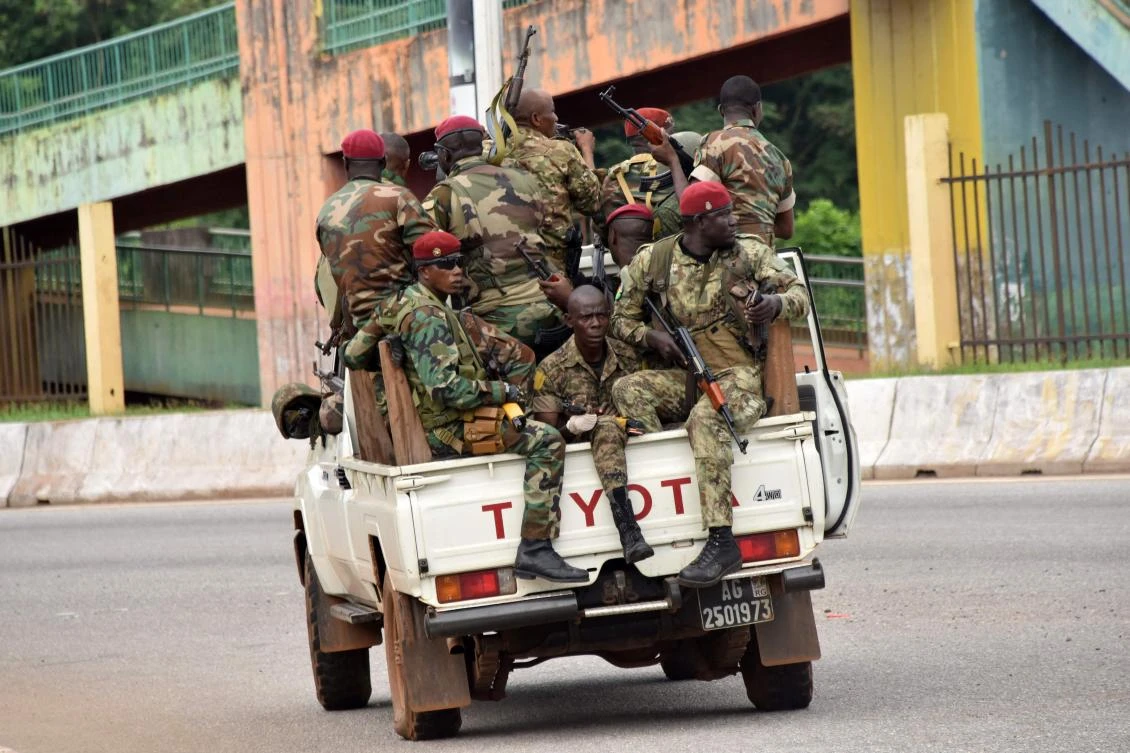 Members of the Armed Forces of Guinea drive through the central neighborhood of Kaloum in Conakry on Sunday after sustained gunfire was heard. (AFP)
