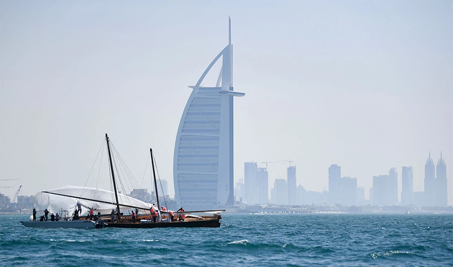 The crew of a competing boat in the annual long-distance "60ft Dubai Traditional Dhow Sailing Race", work on the sail across from Burj Al Arab, with the Dubai skyline visible in the background, in the United Arab Emirates, on March 7, 2020. (AFP)