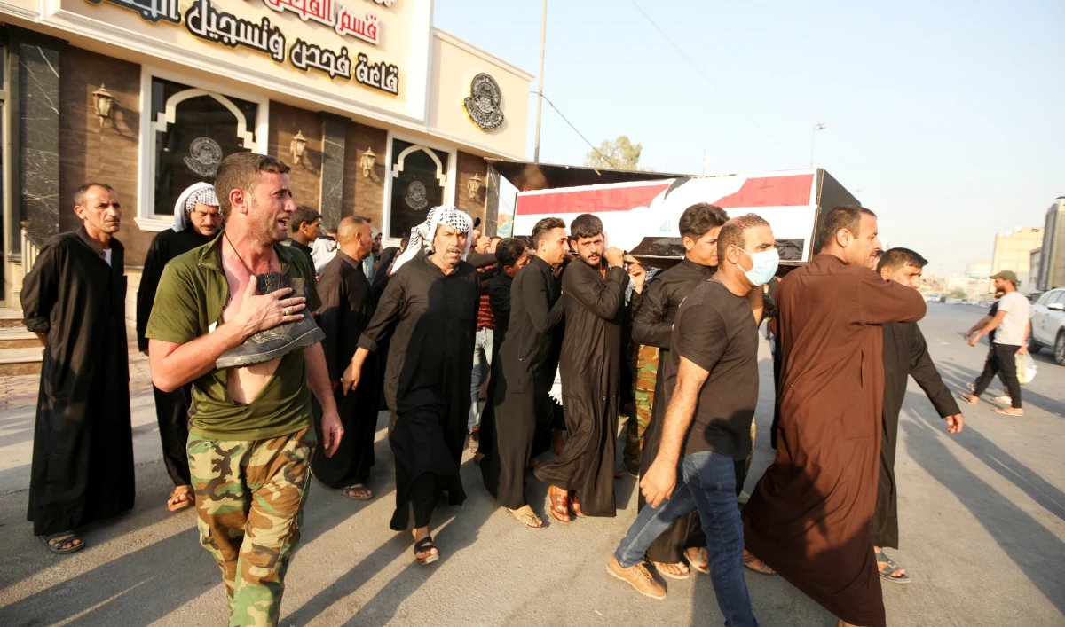 Mourners carry the coffin of a policeman, who was killed in an attack in Kirkuk, during a funeral in Najaf, Iraq, September 5, 2021. (REUTERS)