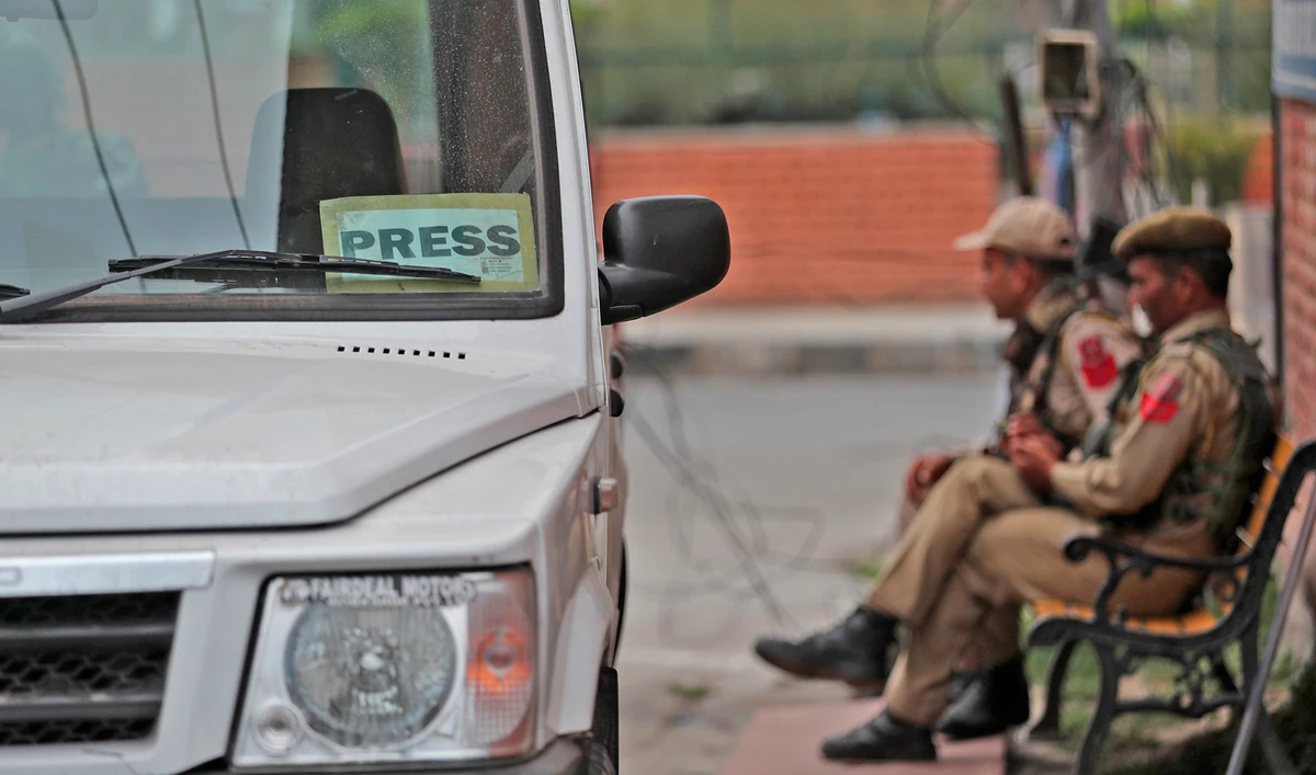 Indian policemen rest on a bench at the entrance of Press Enclave in Srinagar on September 8, 2021. (AP)