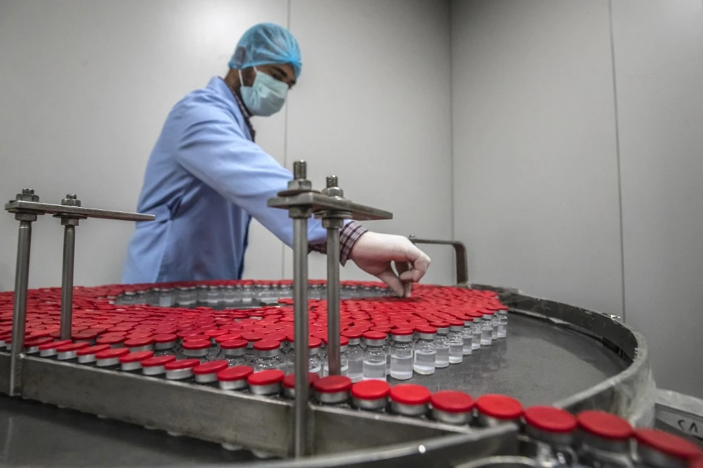 Laboratory workers supervise the production of vials of China's Sinovac COVID-19 vaccine in Cairo. (File/AFP)