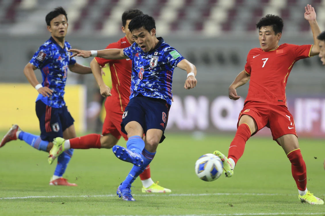 Japan’s Wataru Endo shoots by China’s Lei Wu during a FIFA World Cup qualifying match between China and Japan in Qatar on Tuesday. (AP)