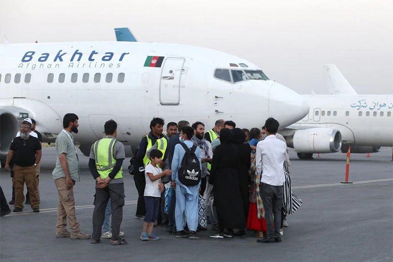 Dual-nationality passengers who have missed their flight for Qatar speak with an airport official at the international airport in Kabul, Afghanistan, September 9, 2021. (REUTERS)