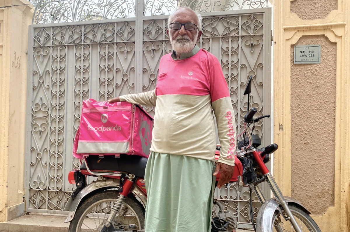 Fayyaz Akhtar Faizi, 73, who works as a food rider, is seen wearing the signature Food Panda uniform at his residence in Islamabad on Wednesday. (AN photo)