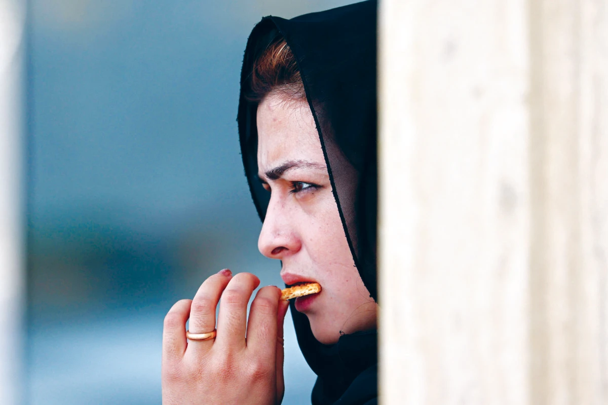 An Afghan woman eats a biscuit in Kabul on Saturday. The UN report said the Taliban’s takeover of the country has put 20 years of ‘steady economic gains at risk.’ (AFP)