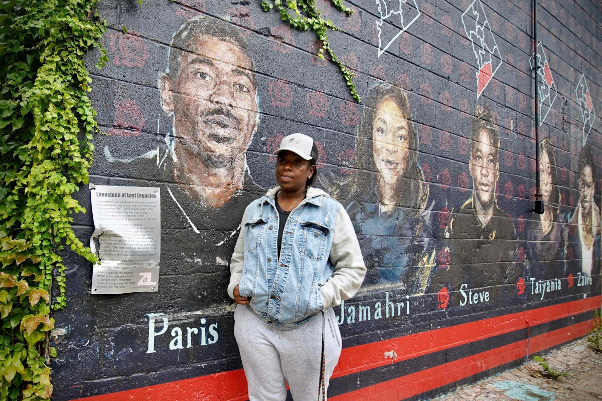 Seditra Brown stands next to a mural depicting her son Paris Brown in the US capital on Sept. 9, 2021. (Photo by Agnes Bun / AFP)