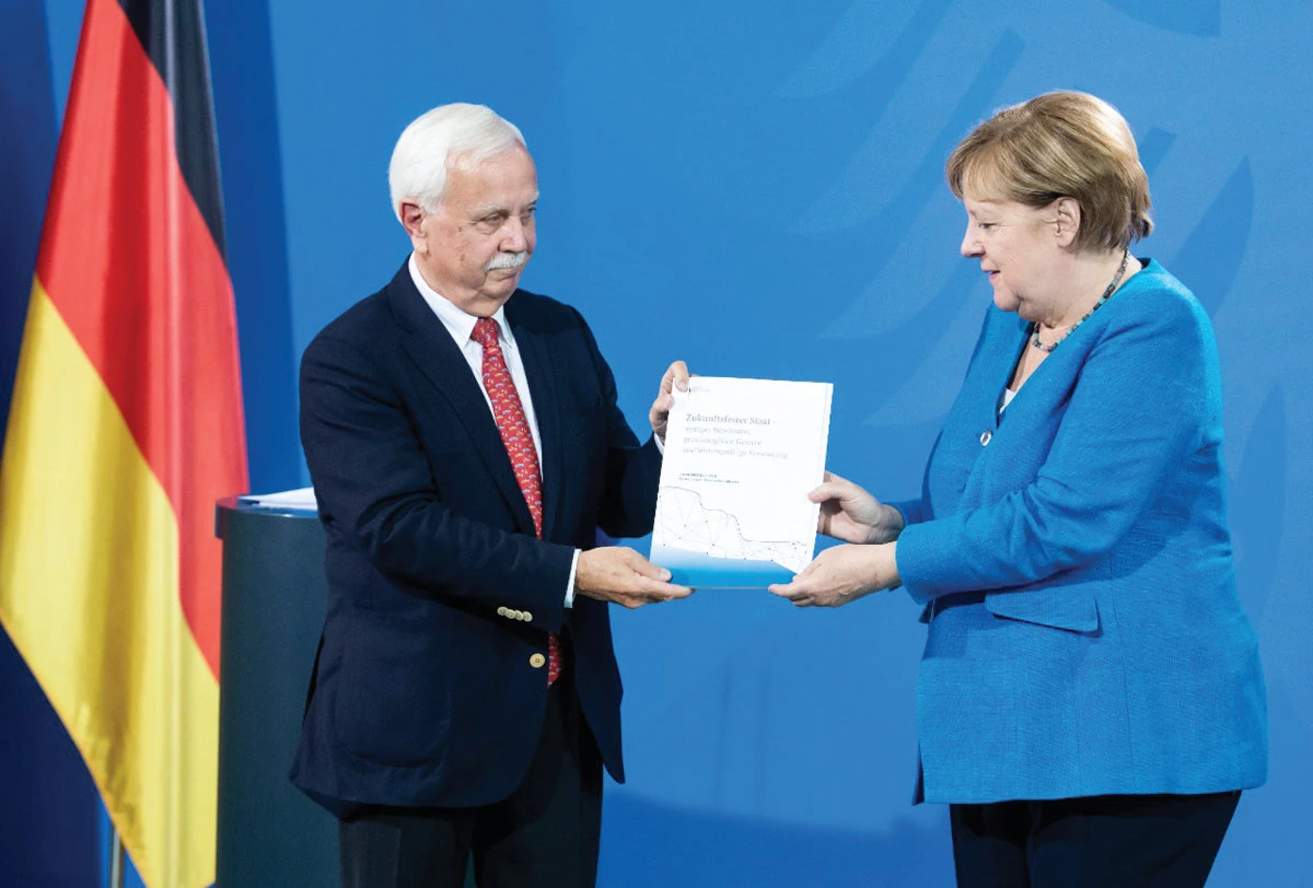 German Chancellor Angela Merkel receives the annual report of the National Regulatory Control Council from the chairman, Johannes Ludewig. (Reuters)