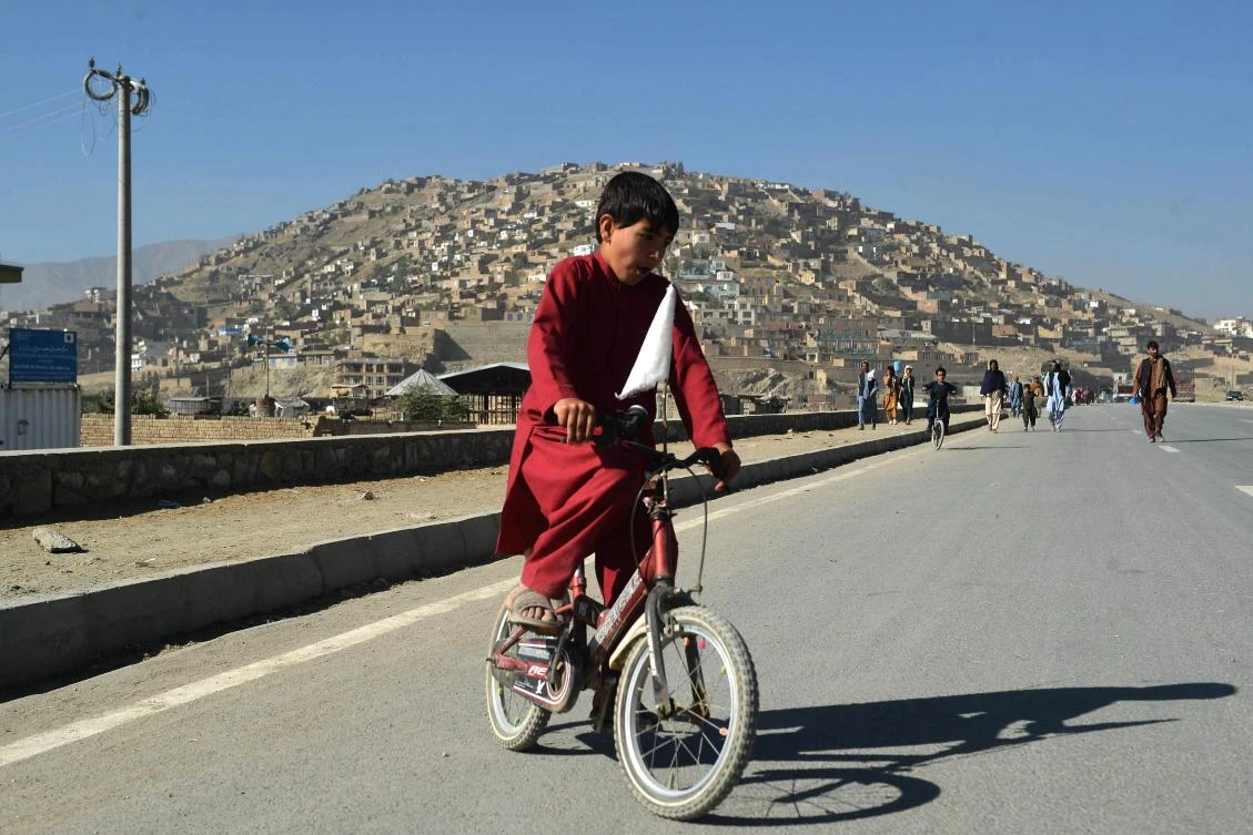 An Afghan boy rides a bicycle in Kabul on Friday when Taliban’s education ministry said all male students of grades 6 to 12 and male teachers should resume classes across Afghanistan starting on Saturday. (AFP)