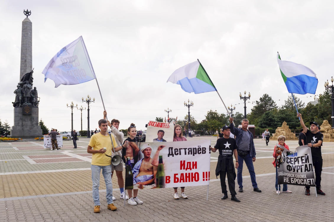 A small group of demonstrators hold posters reading "Degtyaryov, go to the bathhouse!!!" and "I'm, we are Sergei Furgal" in Khabarovsk, Russia, in the country's Far East, on Saturday, Sept. 11, 2021. (AP)