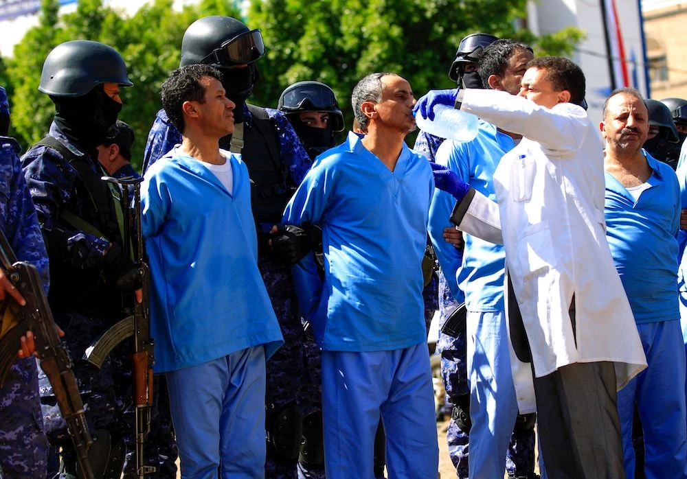 A medic gives a defendant water before being executed after being convicted with eight others of involvement in the assassination of Huthi political leader Saleh Al-Samad three years ago. (AFP)