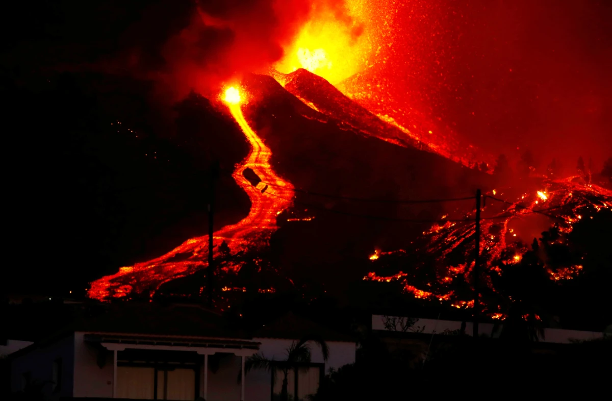 Lava flows next to a house following the eruption of a volcano in the Cumbre Vieja national park at El Paso, on the Canary Island of La Palma, September 19, 2021. (REUTERS)