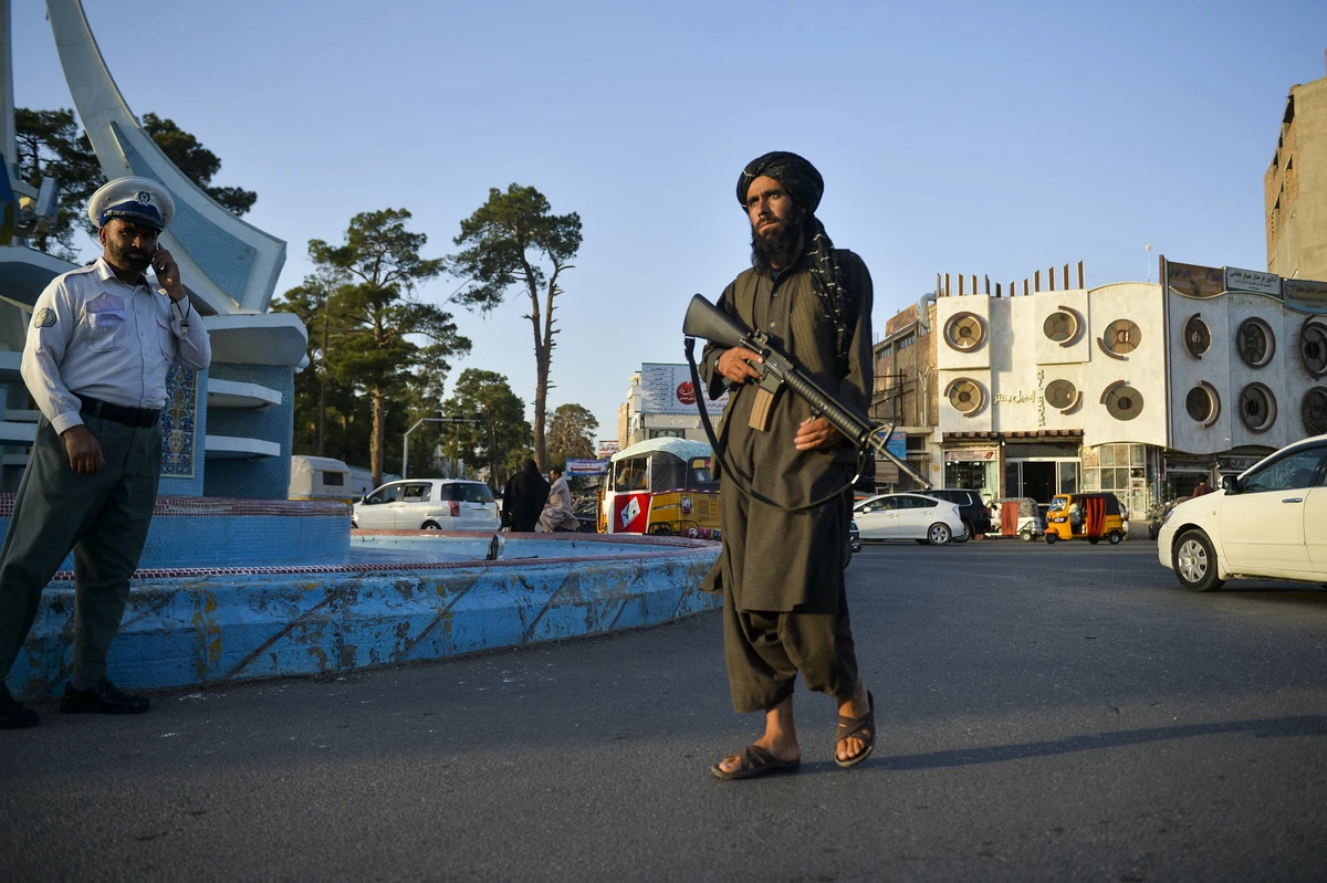 In this picture taken on September 19, 2021, a Taliban fighter (R) patrols along a street in Herat. (AFP)