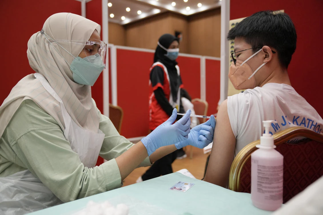 A secondary school student receives a dose of the Pfizer vaccine against the coronavirus disease in Shah Alam, Malaysia on Sept. 20, 2021. (AP)