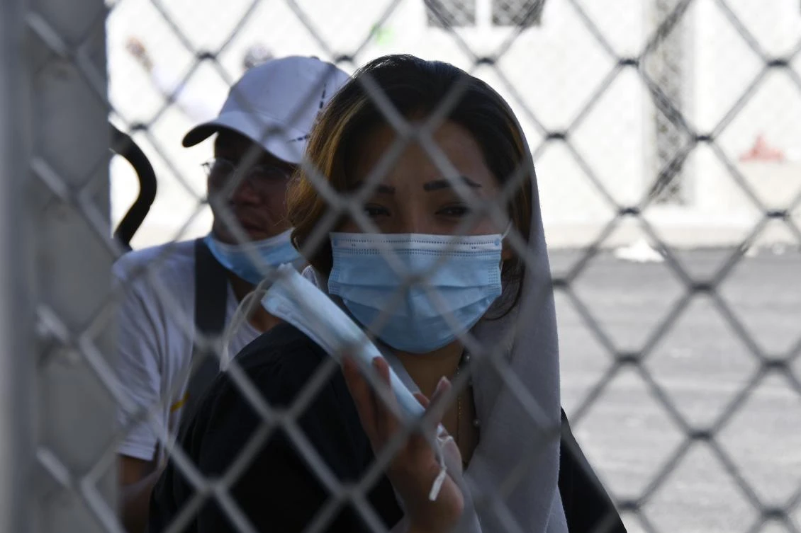 Migrants sit behind a fence at the new closed monitored facility in Zervou village, on the eastern Aegean island of Samos, Greece, Monday, Sept. 20, 2021. (AP Photo)