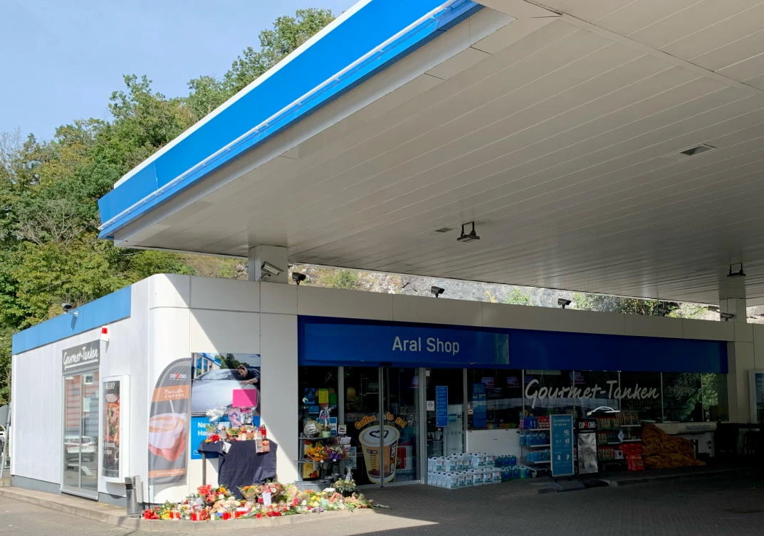 Flowers are placed at a gas station in Idar-Oberstein, Germany on Tuesday after a 20-year-old gas station attendant who asked a customer to wear a face mask was shot dead on Saturday. (Reuters)