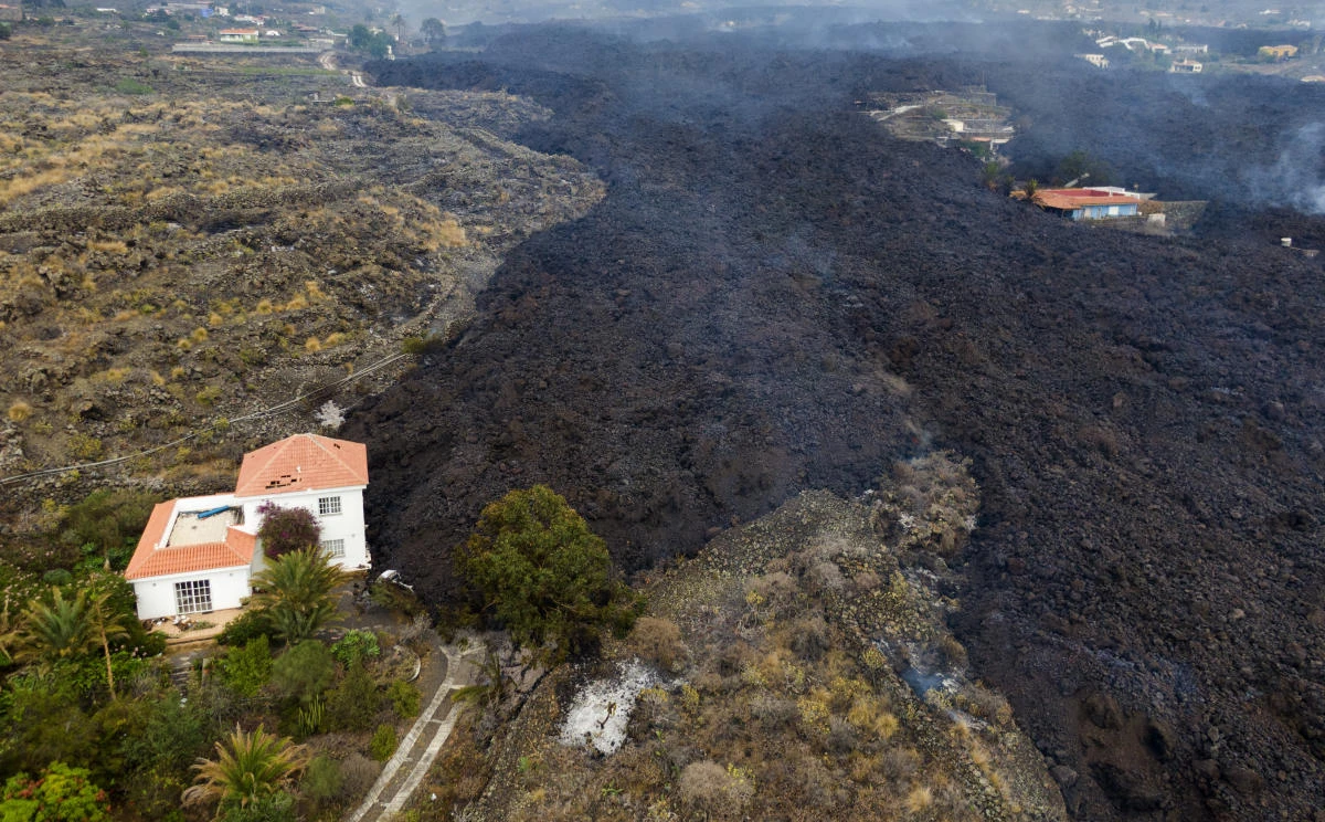 Lava from a volcano eruption flows destroying houses on the island of La Palma in the Canaries, Spain, on Tuesday. (AP)