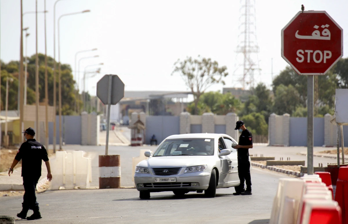 A member of Tunisian police controls a Libyan citizen driving his car towards the Libyan border, at the border post in Ras Jdir in south-eastern Tunisia. (AFP)