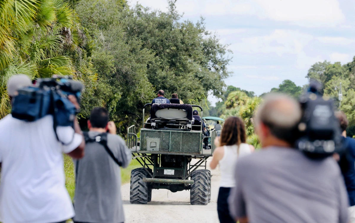Law enforcement teams drive swamp buggies down a dirt road on the Southside of the Carlton Reserve, while searching for any signs of Brian Laundrie on Sept. 21, 2021. (Naples Daily News via AP)