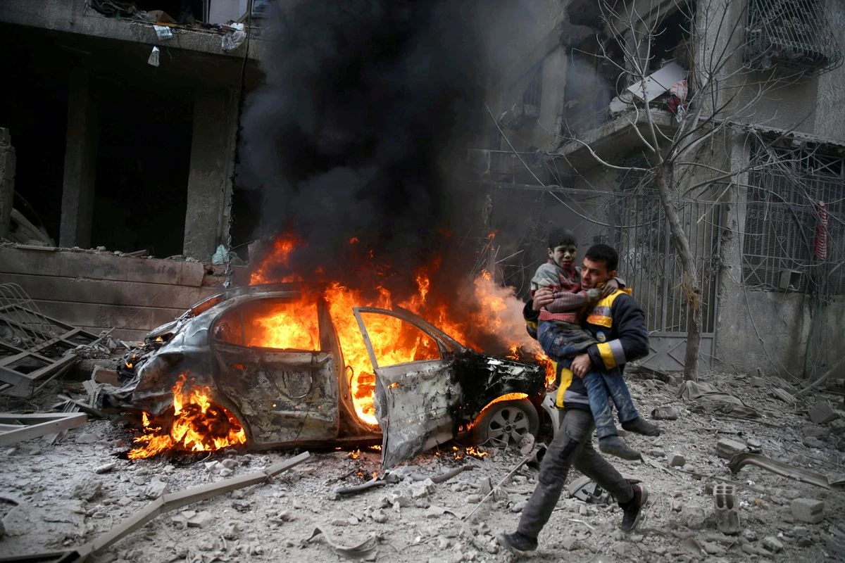 A Syrian Civil Defence member carries a wounded child in the besieged town of Hamoria, Eastern Ghouta, in Damascus, Syria January 6, 2018. (Reuters/File Photo)