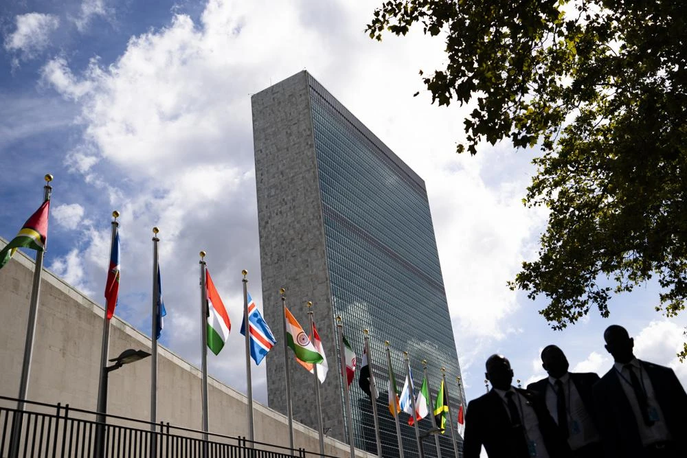 Members of a delegation's entourage wait outside a security checkpoint on the sidewalk in front of the United Nations headquarters, Tuesday, Sept. 21, 2021, during the 76th Session of the U.N. General Assembly in New York. (AP)