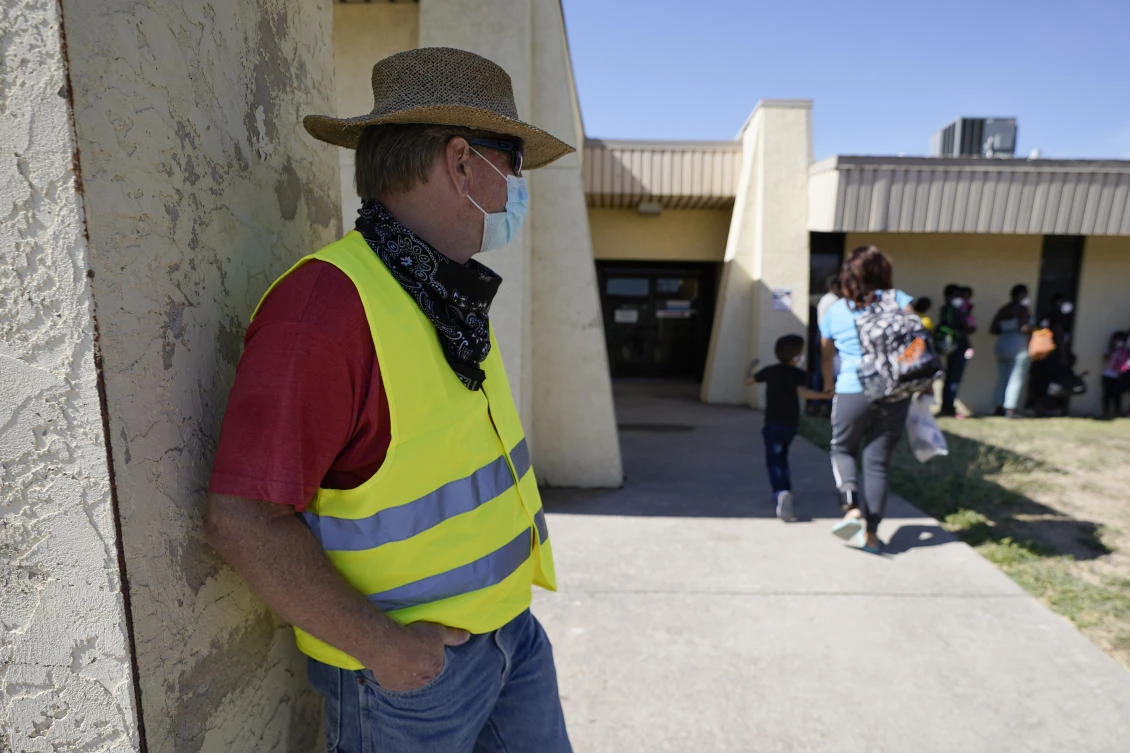 Dave, from Toledo, Ohio, wears a neon vest as migrants are released from US Customs and Border Protection custody on Friday in Del Rio. He drove down to Southwest Texas in hopes of picking up his friend Ruth and her family. (AP)
