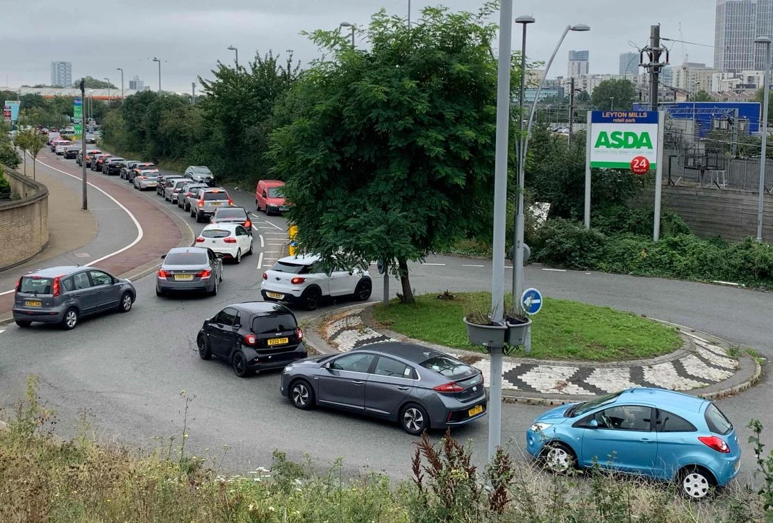 Customers queue to access an Asda petrol station in east London on Sept. 25, 2021. (AFP)