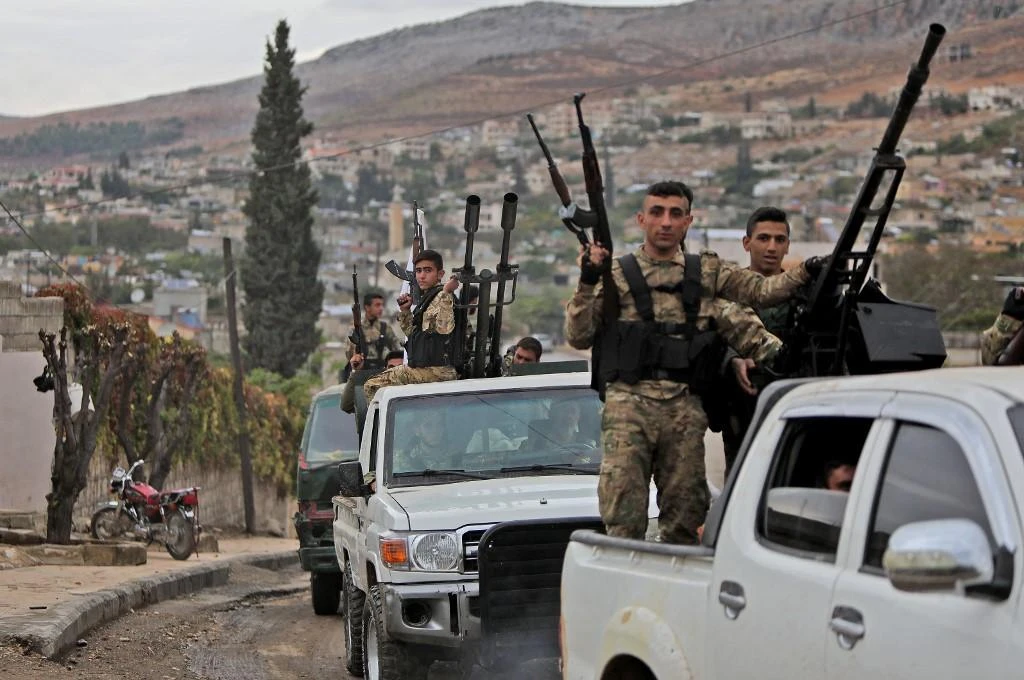 Syrian fighters from the Turkish-backed Hamza faction drive through the village of Bassouta, south of the city of Afrin on Nov. 4, 2020. (AFP)