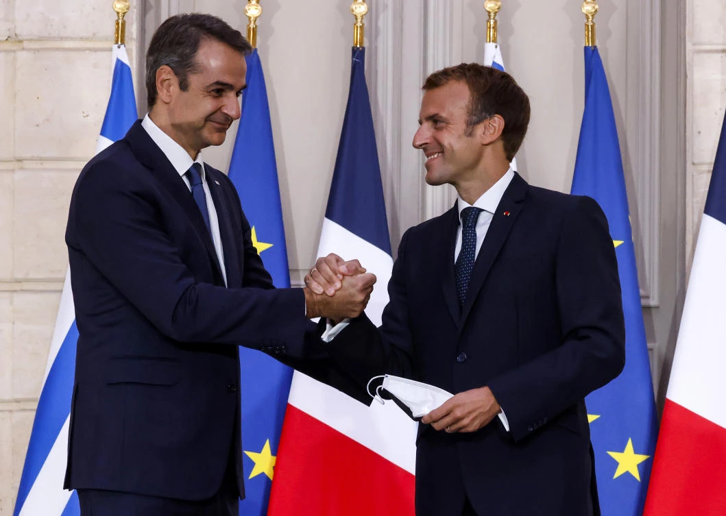 Greek Prime Minister Kyriakos Mitsotakis, left, and French President Emmanuel Macron shake hands after the signing of a new defense deal at The Elysee Palace Tuesday, Sept. 28, 2021 in Paris. (AP)
