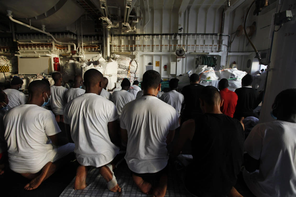 Migrants pray on the deck of the Geo Barents, a rescue vessel operated by MSF (Doctors Without Borders) off Libya, in the central Mediterranean route last Wednesday. (AP)