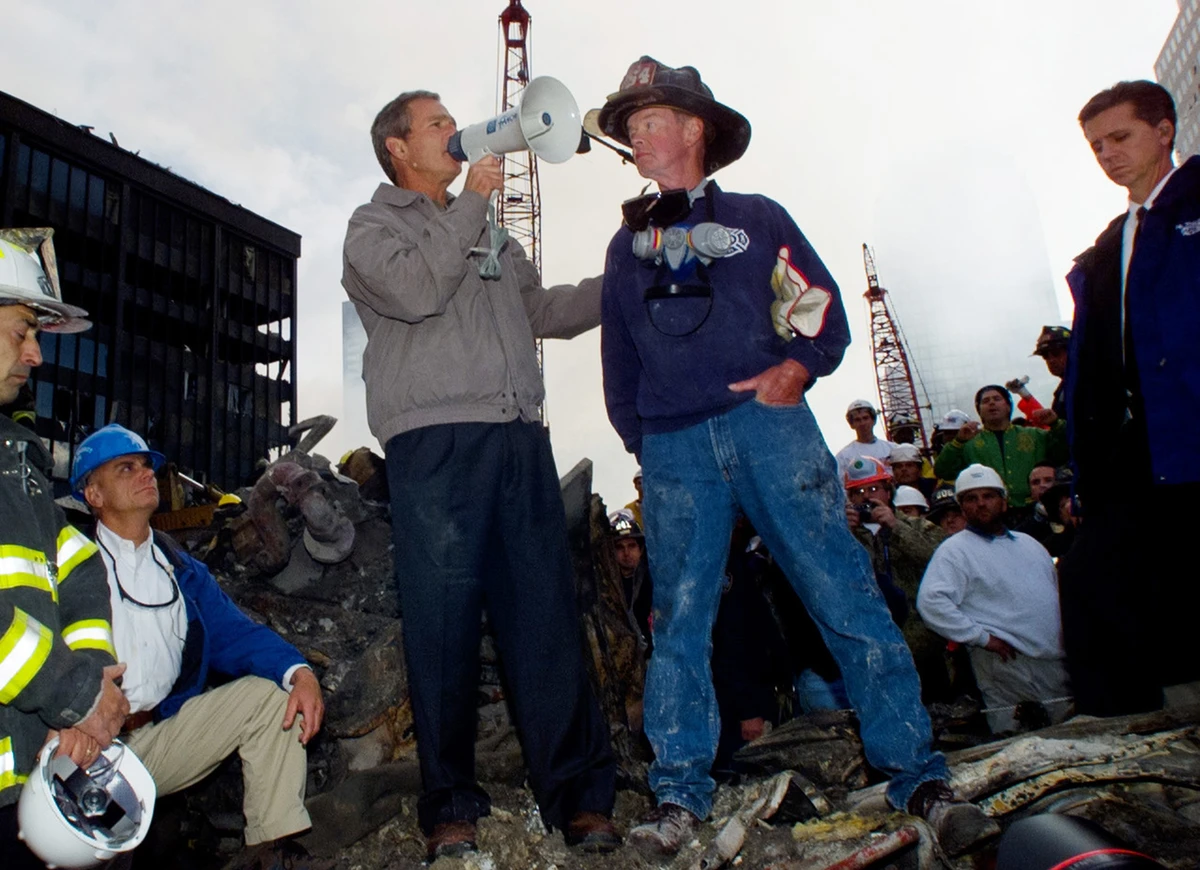 President George Bush stands with firefighter Bob Beckwith on a burnt fire truck in front of the World Trade Center, Friday, Sept. 14, 2001. (AP Photo)