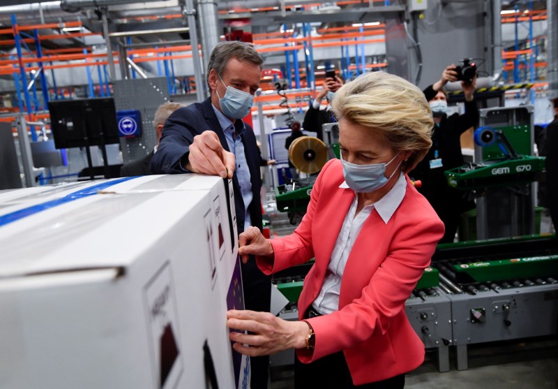 Ursula von der Leyen places a EU flag label during a visit to the factory of U.S. pharmaceutical company Pfizer in Puurs, Belgium, April 23, 2021. (Reuters)