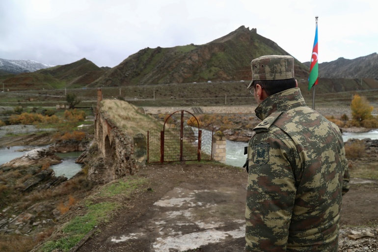 An Azeri service member looks at one of the bridges at Khodaafarin, spanning the Aras river, on the border with Iran. (Reuters)