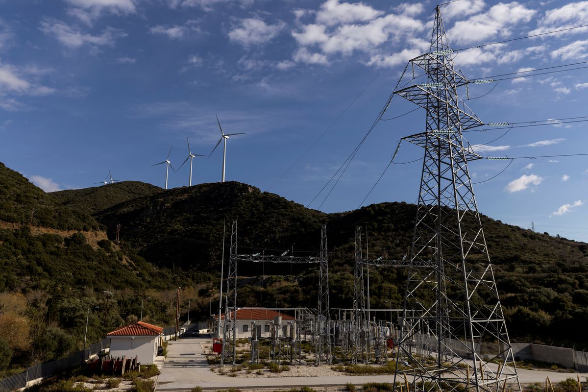 Wind turbines are seen on a hill in front of a power station near the village of Macynia, Greece, March 17, 2021. (Reuters)