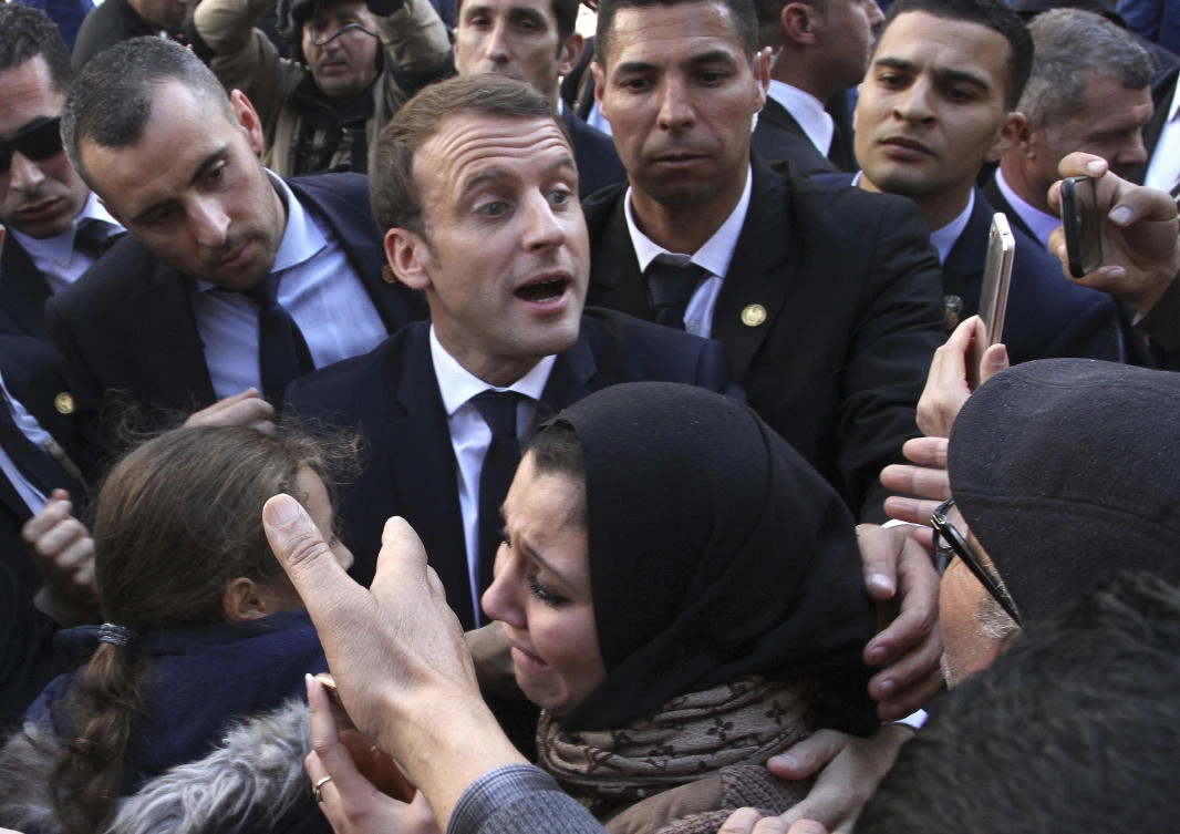 French President Emmanuel Macron meets residents in Algiers. Algeria has announced the immediate recall of its ambassador from Paris in a burst of fury over what it said were "inadmissible" comments attributed to French President Emmanuel Macron. (AP)