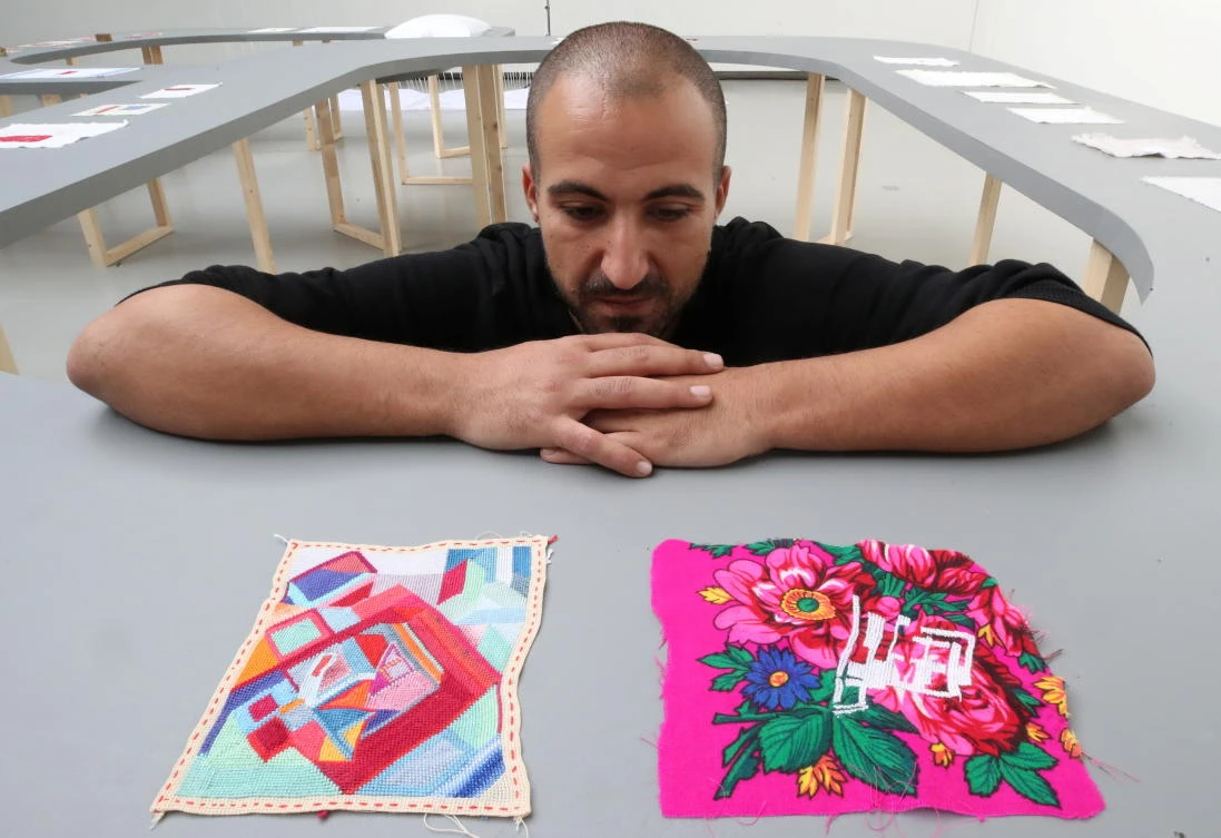 Palestinian artist Majd Abdel Hamid who fled the war in Syria and studied in Beirut only to survive the 2020 Beirut blast, poses during his exhibition “A Stitch in Times” in Brussels on Tuesday. (Reuters)