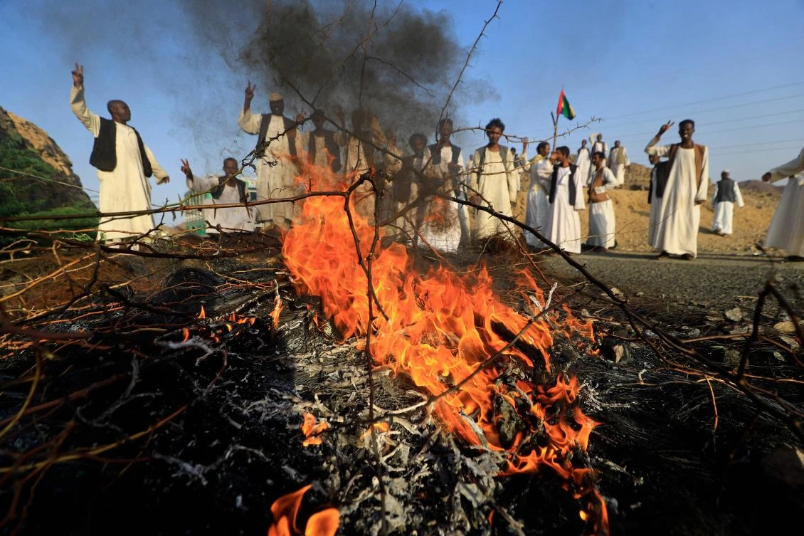 Sudanese from the eastern Beja region block the main road of Port Sudan, 120 km west of the port, on October 5, 2021 as an act of protest against sections regarding the eastern region of Sudan in the Juba Peace Agreement. (AFP)