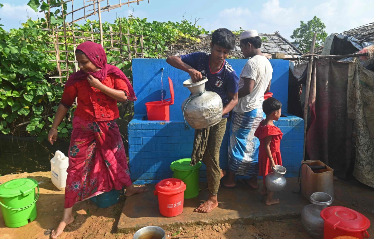 Rohingya refugees collect drinking water at Kutupalong refugee camp in Ukhia, Bangladesh on October 7, 2021. (AFP)