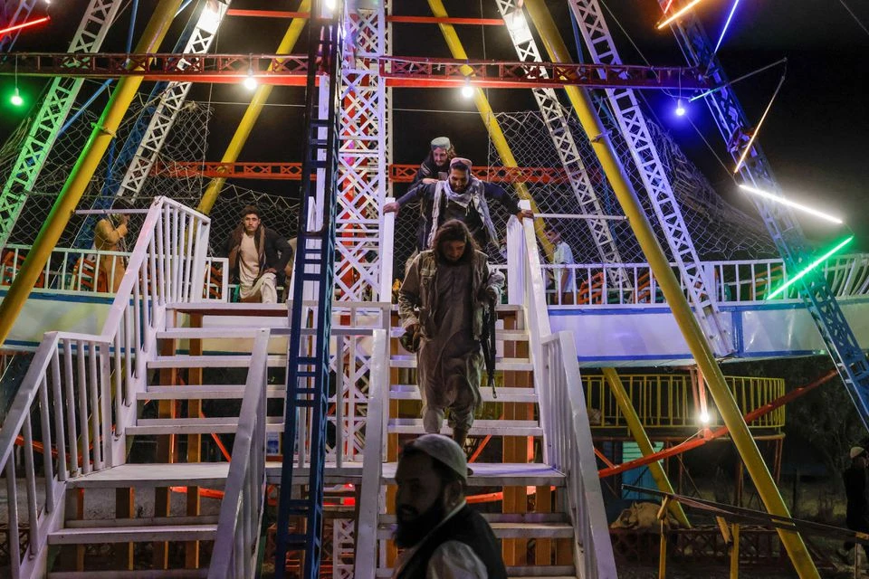 Taliban fighters walk down the stairs as they take a day off to visit the amusement park at Kabul's Qargha reservoir, at the outskirts of Kabul, Afghanistan October 9, 2021. (REUTERS)