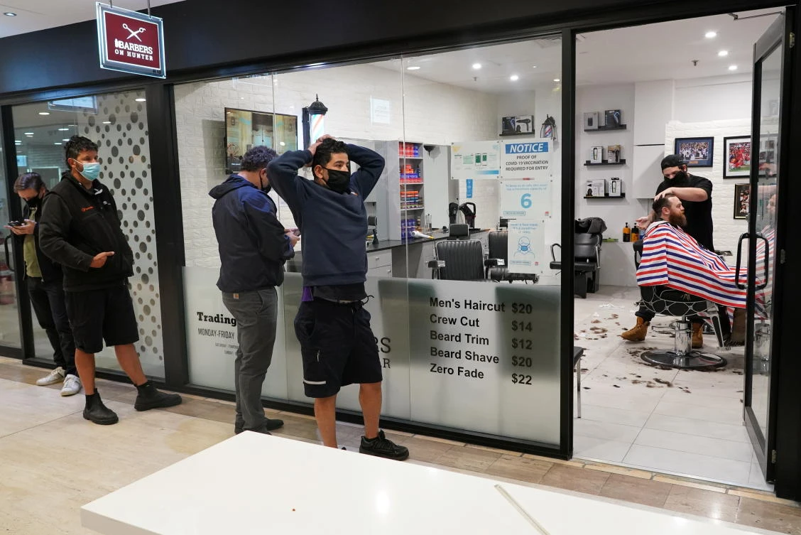Customers wait at a barber shop on the first day of many such businesses re-opening to vaccinated patrons, following months of lockdown orders in Sydney on Oct. 11, 2021. (Reuters)
