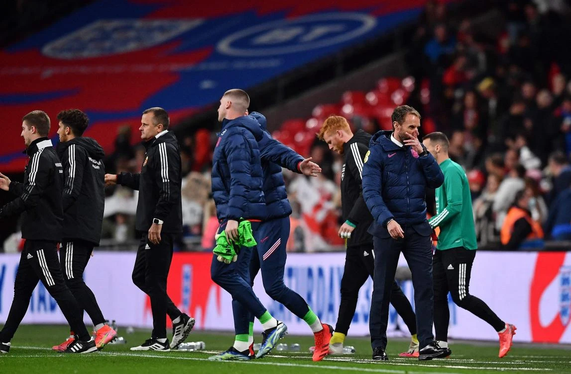 England’s manager Gareth Southgate leaves the pitch as Hungary’s substitutes and coaches walk onto the pitch to huddle following the FIFA World Cup 2022 qualifying match between England and Hungary at Wembley Stadium in London on Tuesday. (AFP)