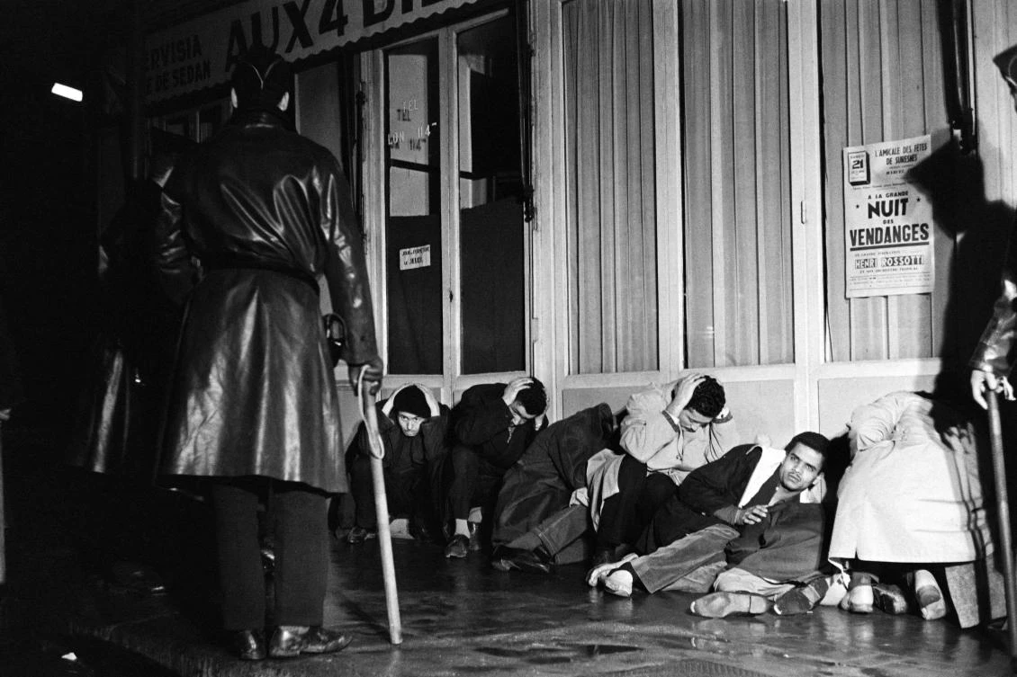 Algerian demonstrators arrested in Puteaux, west of Paris, wait, with their hands above their heads, to be questioned by police, October 17, 1961. (AFP)
