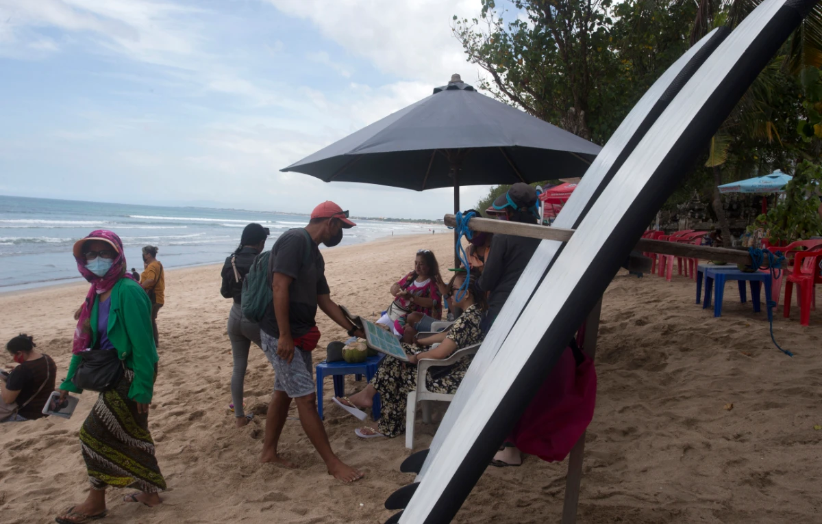 Beach vendors wait for customers at Kuta beach in Bali, Indonesia, Thursday, Oct. 14, 2021. (AP)
