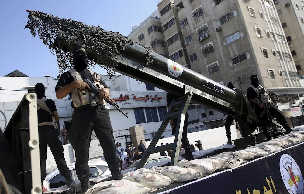 Palestinian members of the Al-Quds Brigades, the military wing of the Islamic Jihad terror group, parade with a replica rocket on a truck during a march in Gaza in 2018. (AP/File Photo)