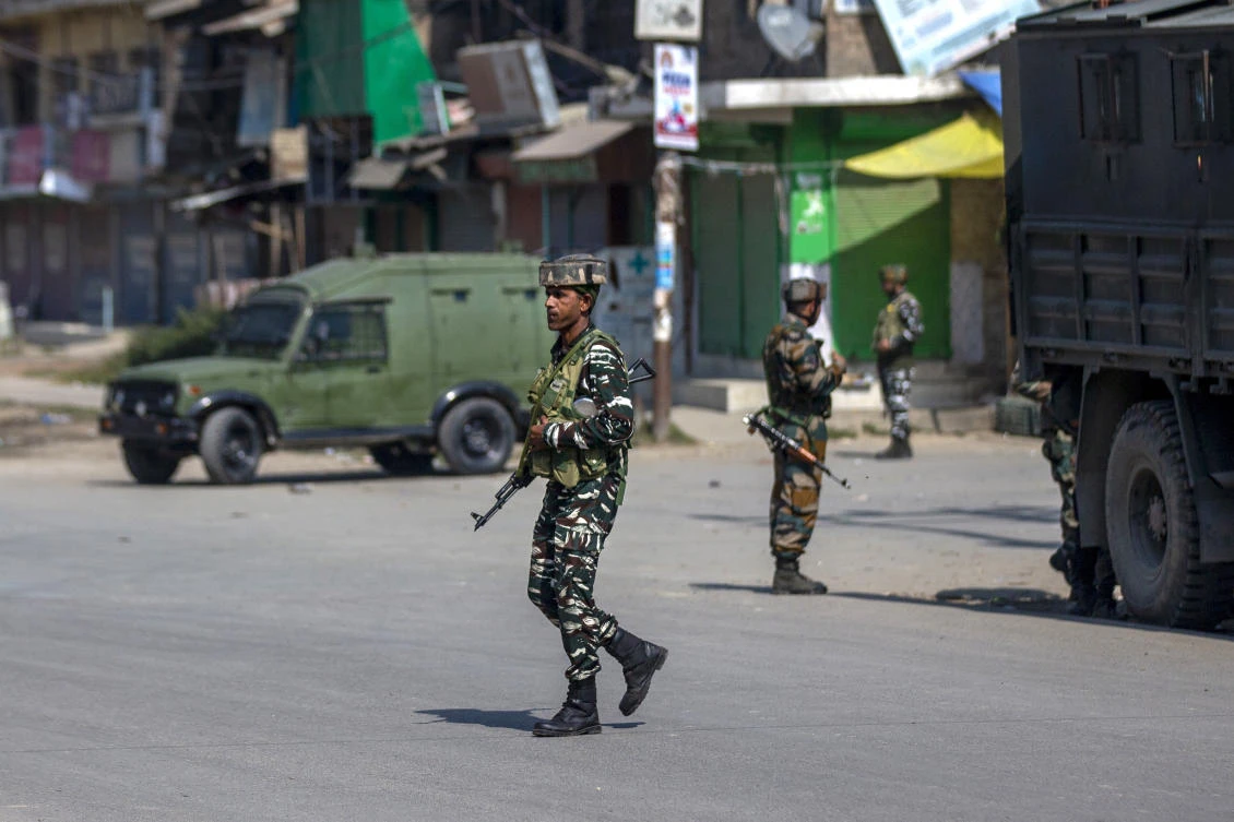 Indian paramilitary soldiers stand guard on a road leading toward the site of a gunfight in Pampore, south of Srinagar, Indian controlled Kashmir, Saturday, Oct. 16, 2021. (AP Photo)