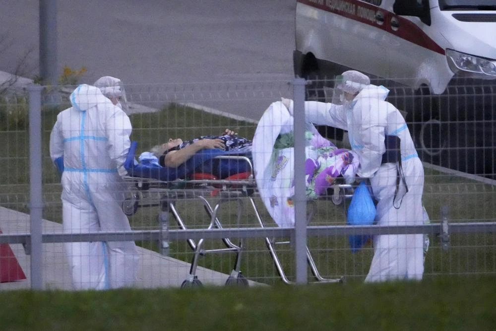 Medical workers carry a patient suspected of having coronavirus on a stretcher at a hospital in Kommunarka, outside Moscow, Russia, Saturday, Oct. 16, 2021. (AP)