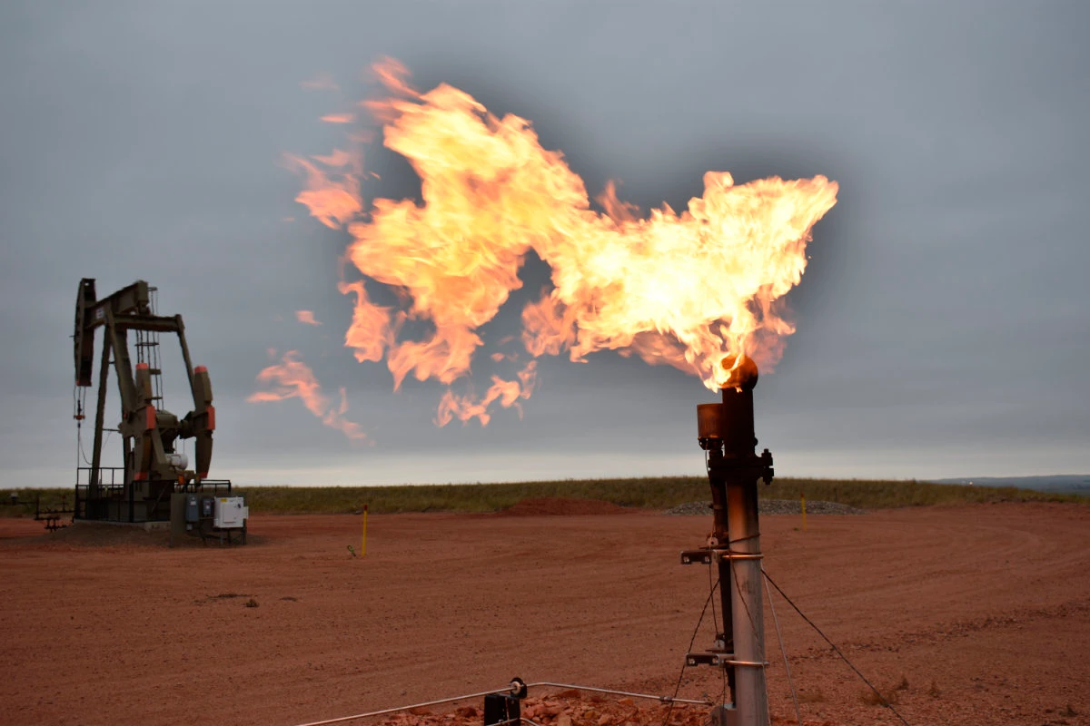 In this Aug. 26, 2021 file photo, a flare burns natural gas at an oil well Aug. 26, 2021, in Watford City, North Dakota, US. (AP Photo/Matthew Brown, file)