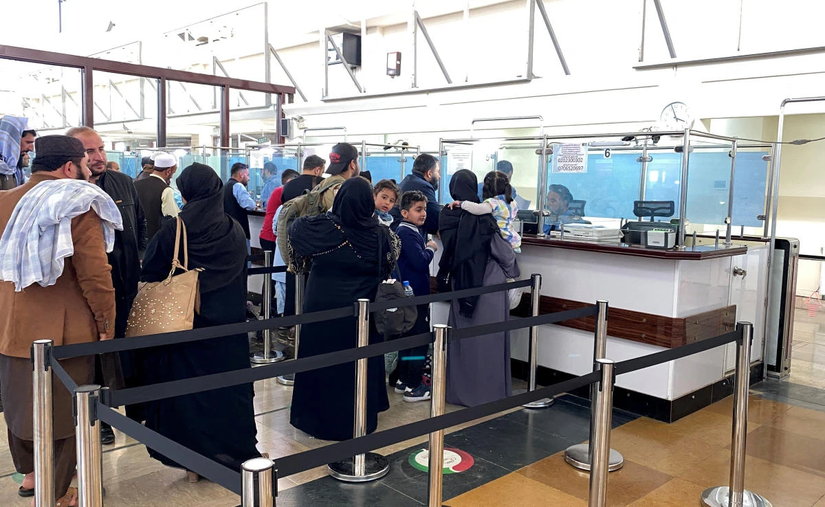 A group of Afghan athletes and their family members wait to board a Qatar airways flight heading to Doha on October 20, 2021, the latest in a series of evacuations from Afghanistan following the Taliban takeover in August. (AFP)