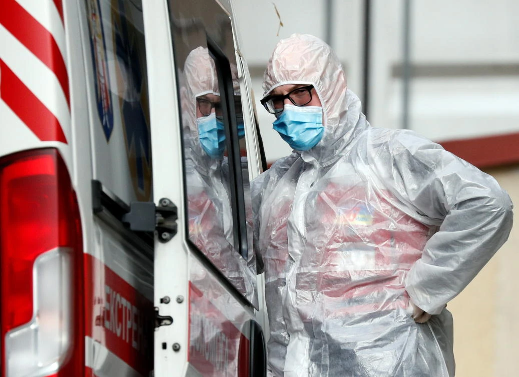 A health worker stands next to an ambulance carrying a COVID-19 patient as they wait in the queue at a hospital for people infected with coronavirus disease in Kyiv, Ukraine October 18, 2021. (Reuters)