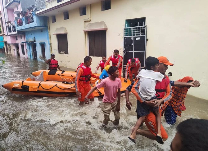 This photograph provided by India’s National Disaster Response Force (NDRF) shows NDRF soldiers rescue people stranded in floodwaters in Udham Singh Nagar, Uttarakhand state, India, Tuesday, Oct. 19, 2021. (AP)